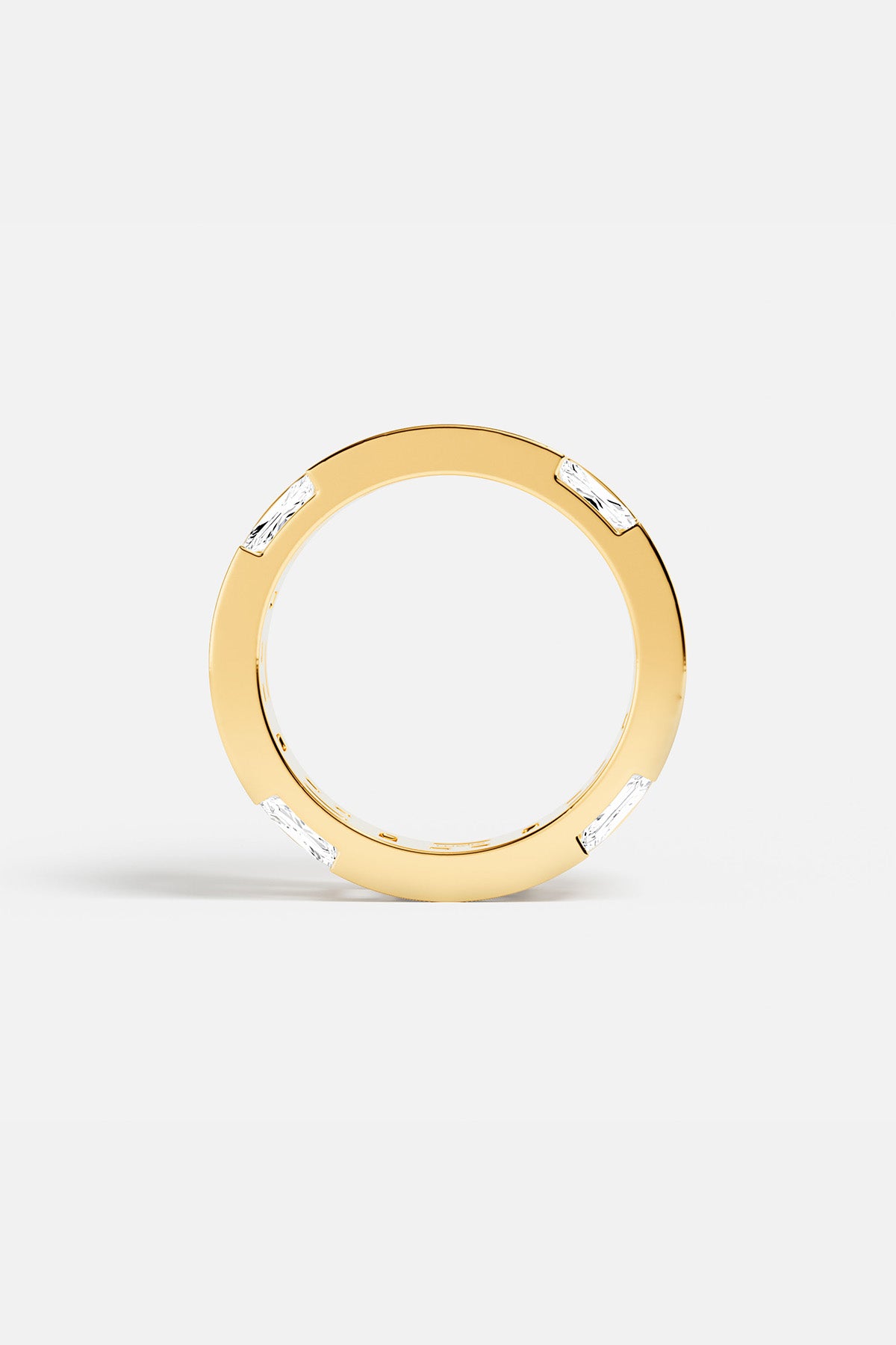 APM Ring in warm gold color, baguette stones punctuating a sleek, modern silhouette.