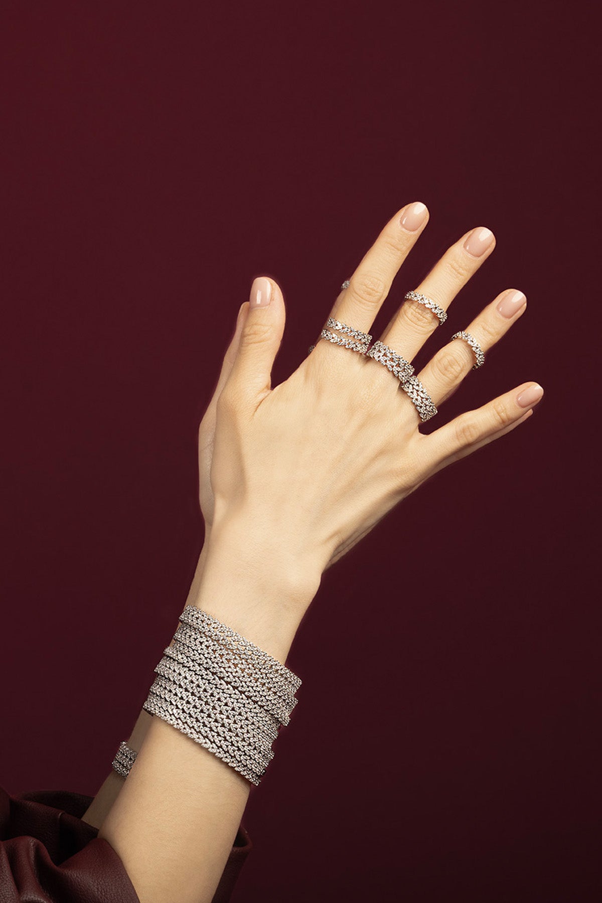 Woman wearing APM Monaco bracelets and rings, layered brilliance for a radiant evening statement.