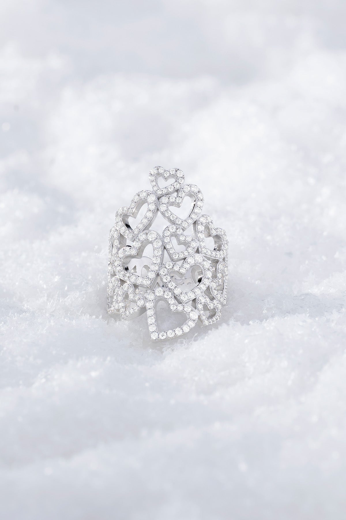 APM MONACO statement heart-shaped ring in silver on a textured snowy background