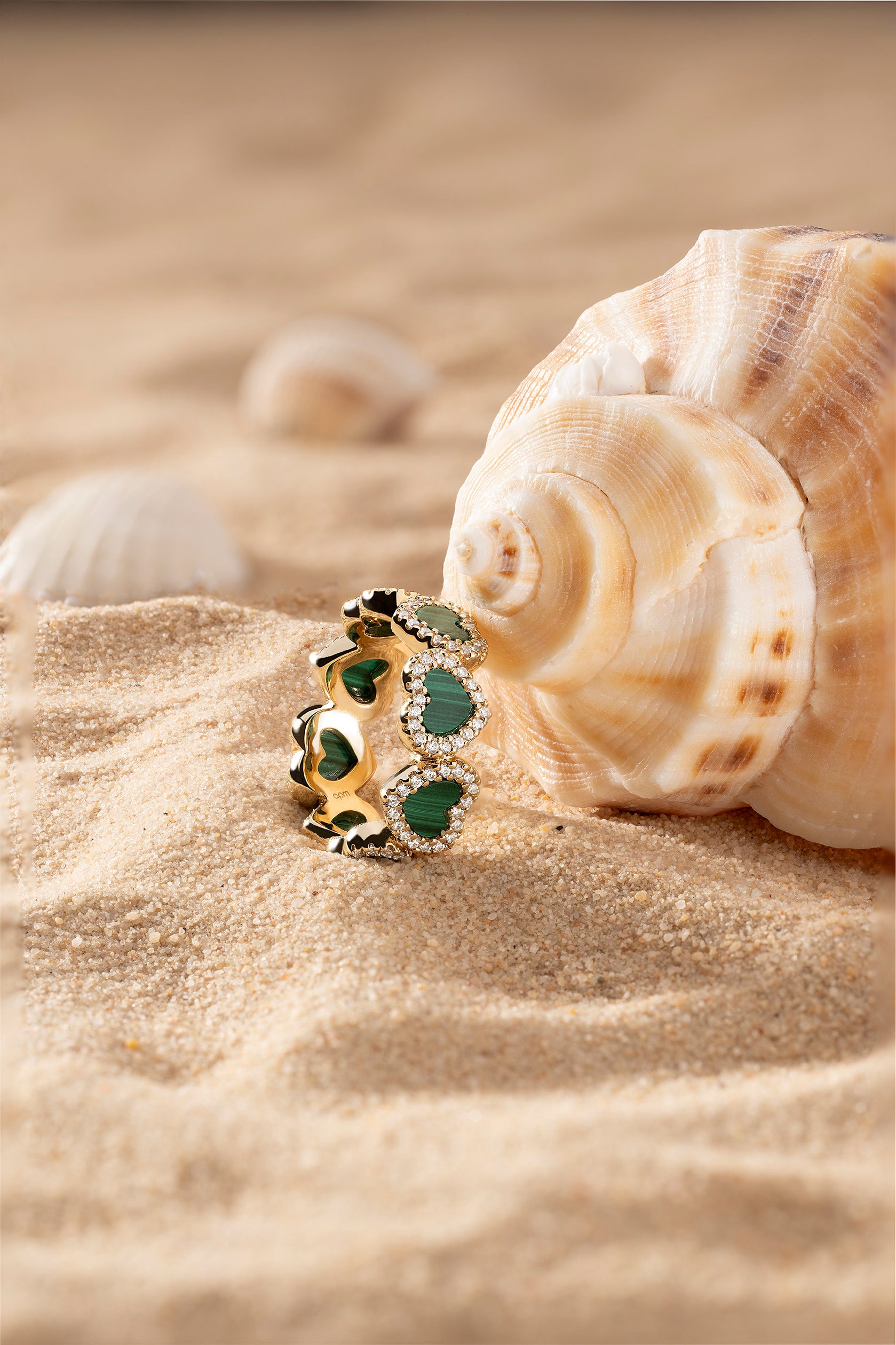 APM Monaco Malachite Heart Ring in Yellow Gold on soft beach