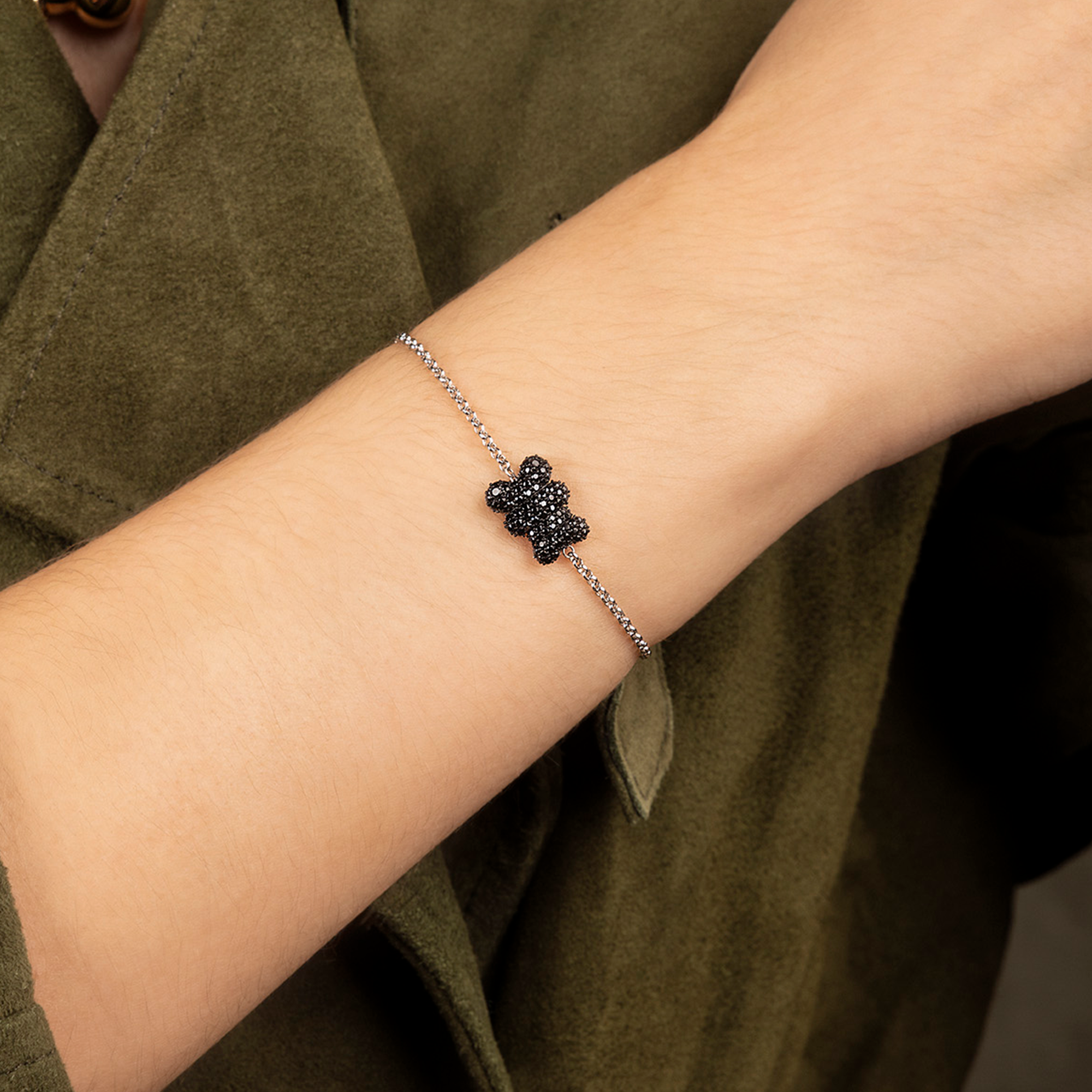APM MONACO black Baby Mood Yummy Bear Adjustable Bracelet worn on hand with green background