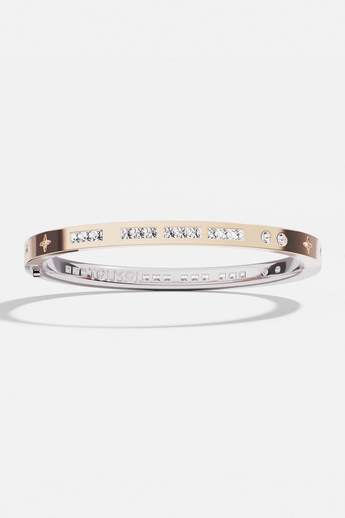 Bracelets APM Monaco two-tone gold and silver bangle with inlaid white stones.