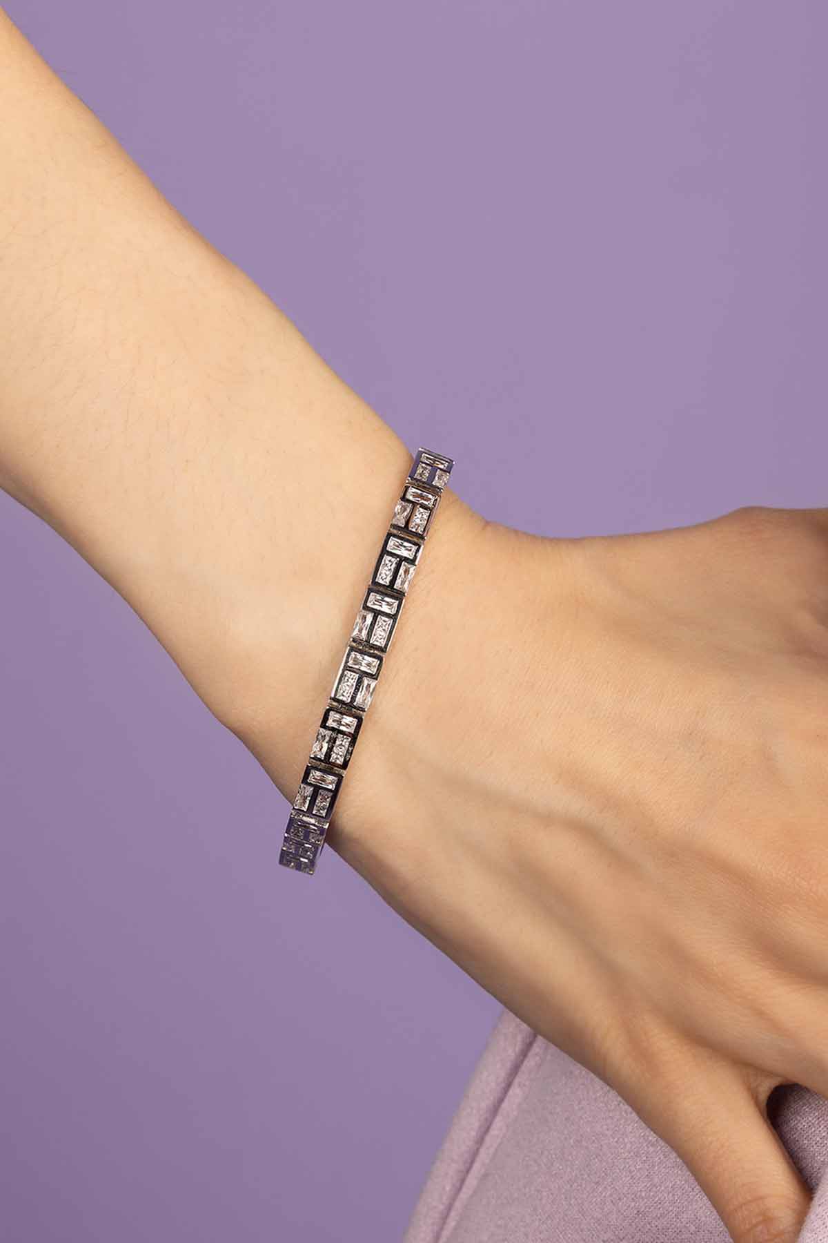 Bracelet on a wrist with a purple background