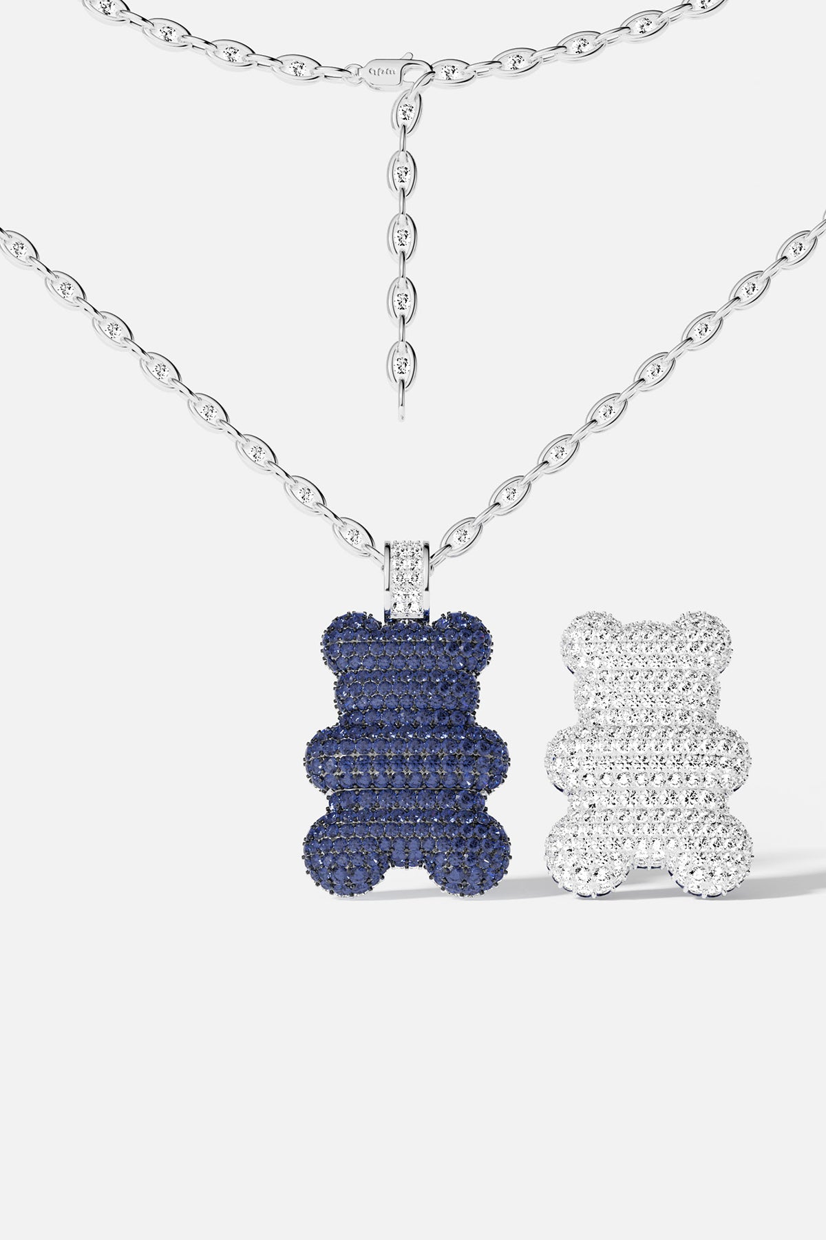 A bear-shaped pendant, different color on both side: blue and silver, on a white background.