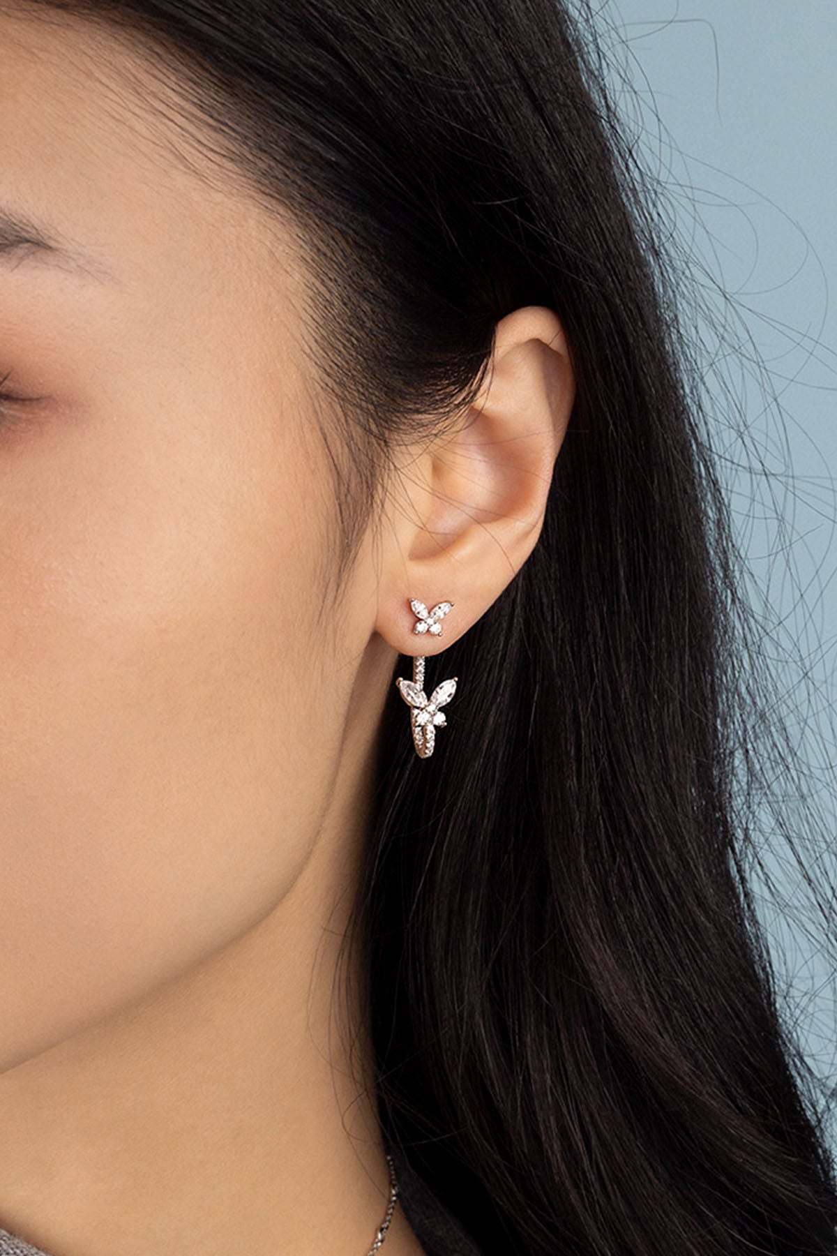 APM Monaco Asymmetric Butterfly Earrings in silver worn on ear