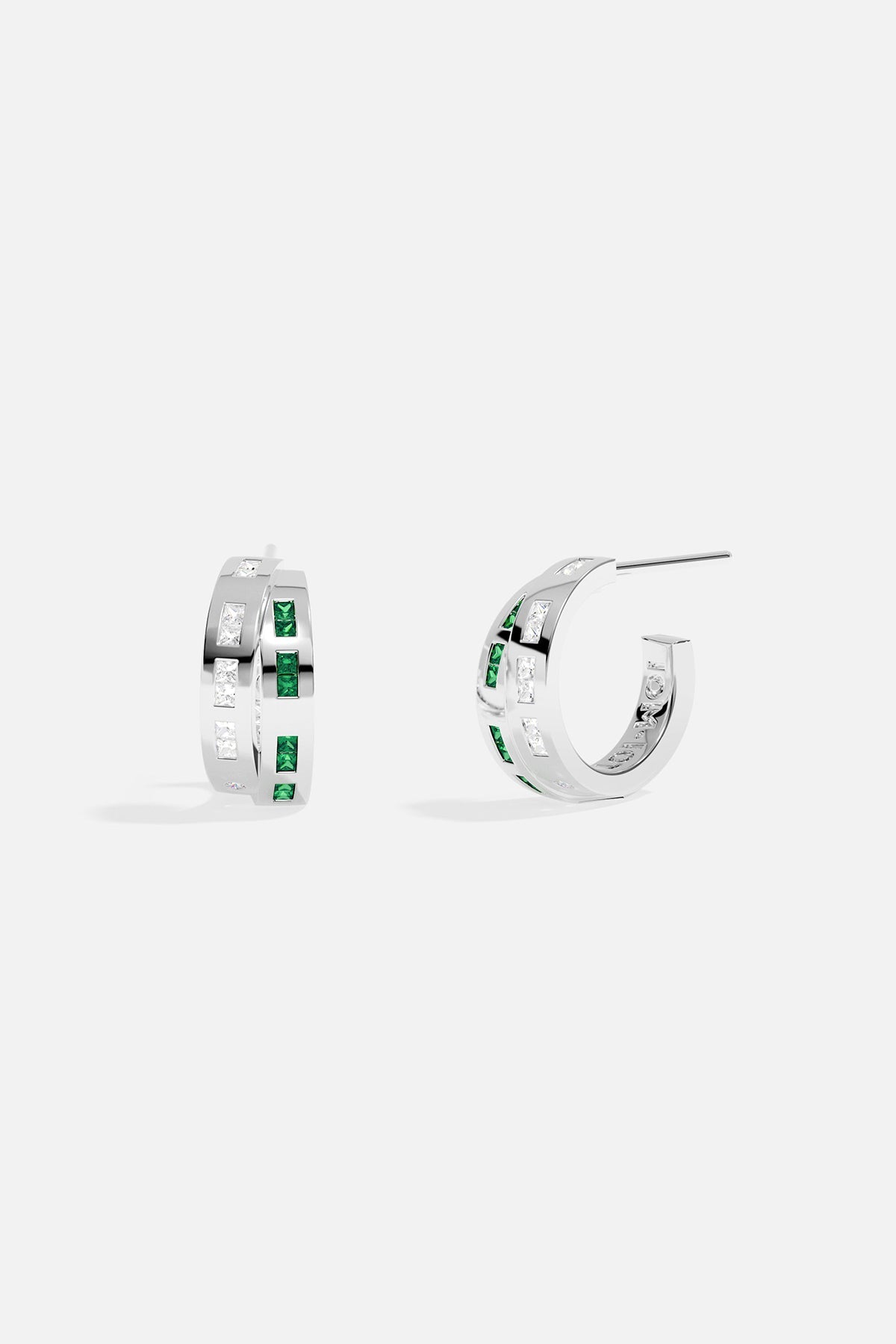Silver hoop earrings with green stones on a white background