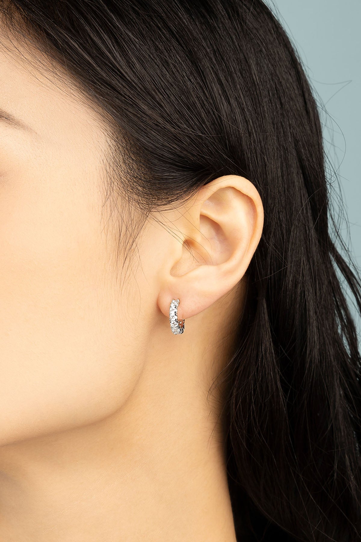 APM Monaco Pavé Huggie Earrings in Silver worn on ear