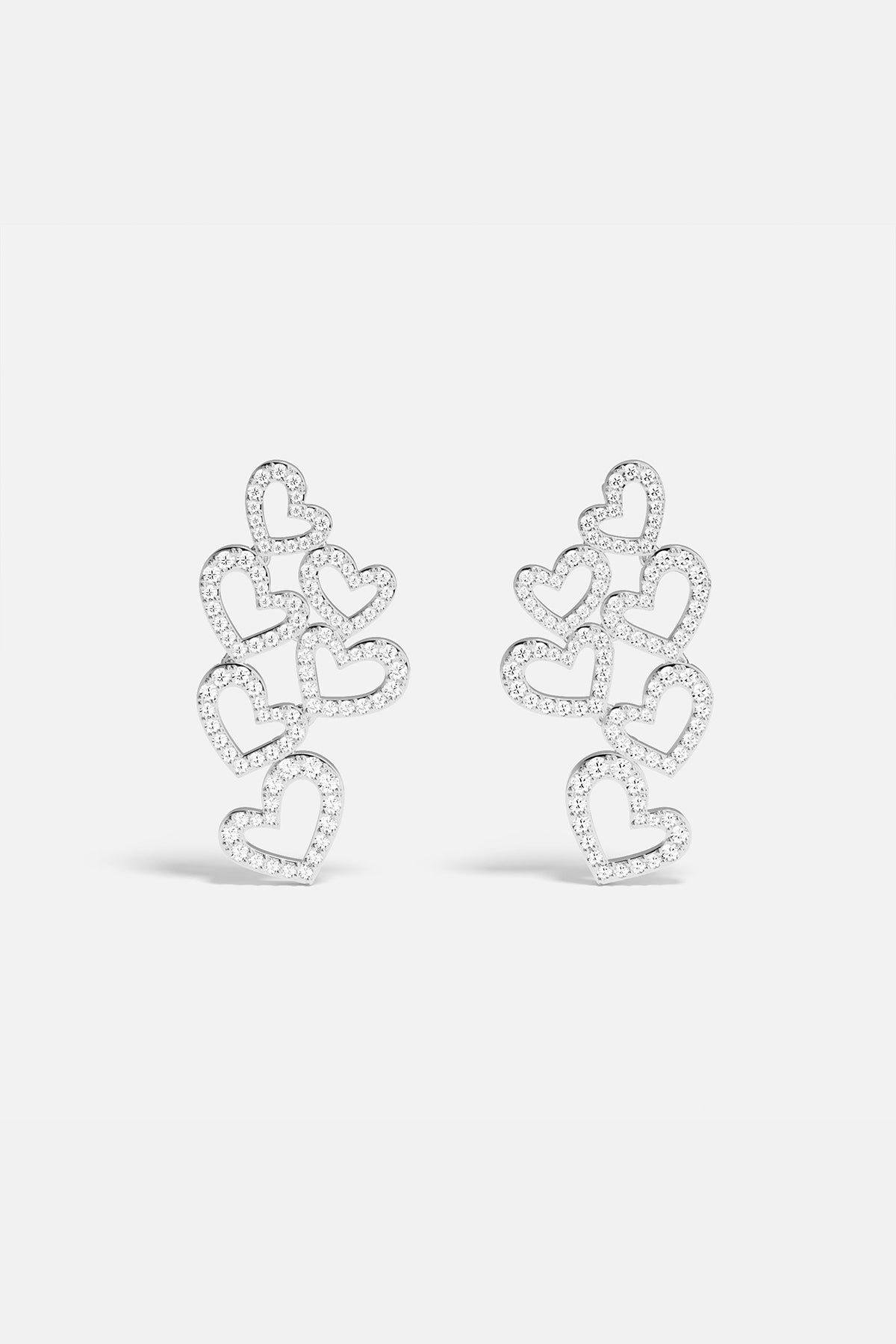APM MONACO heart-shaped earrings in silver on a white background