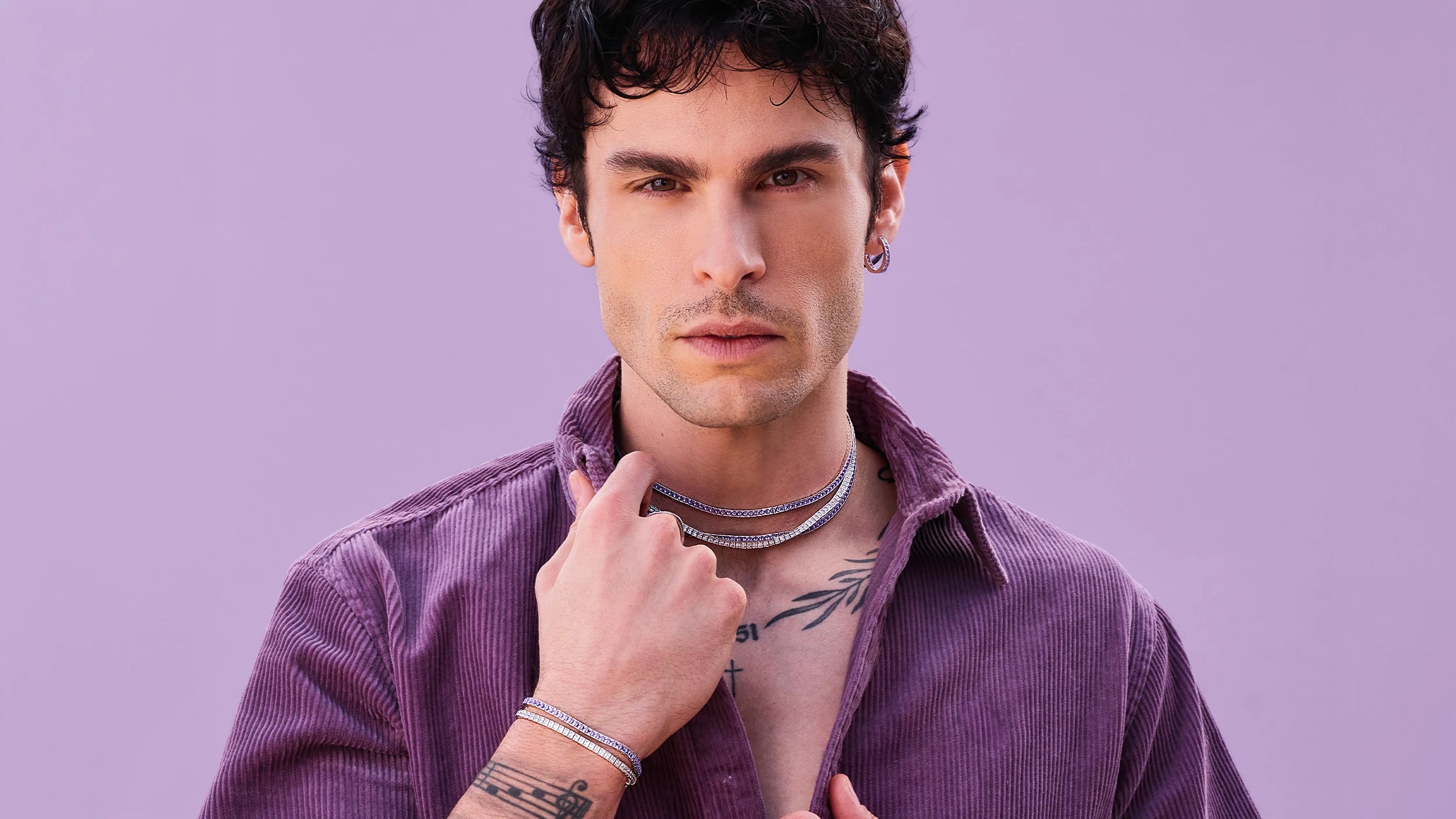 BAPTISTE GIABICONI wearing APM MONACO jewelry set against a light purple background
