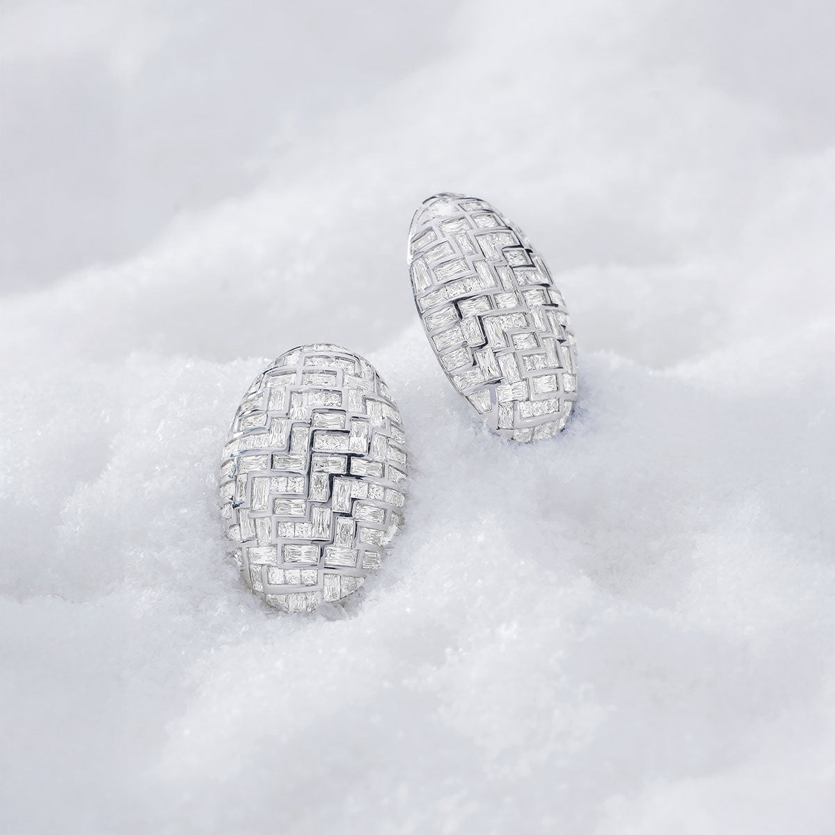Pair of bold white earrings from APM MONACO on a light gray background