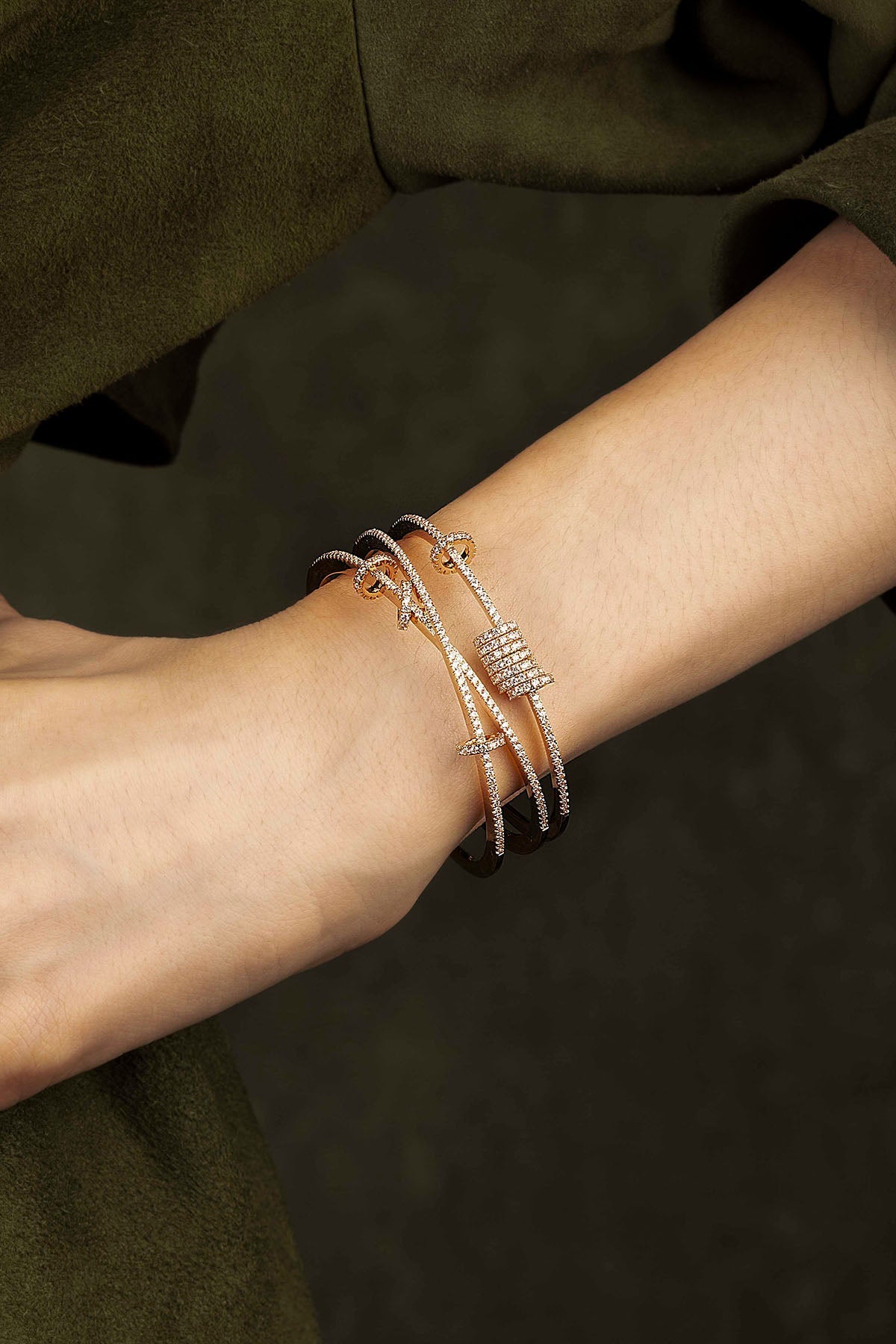 Close-up of a wrist wearing multiple bracelets on a dark background