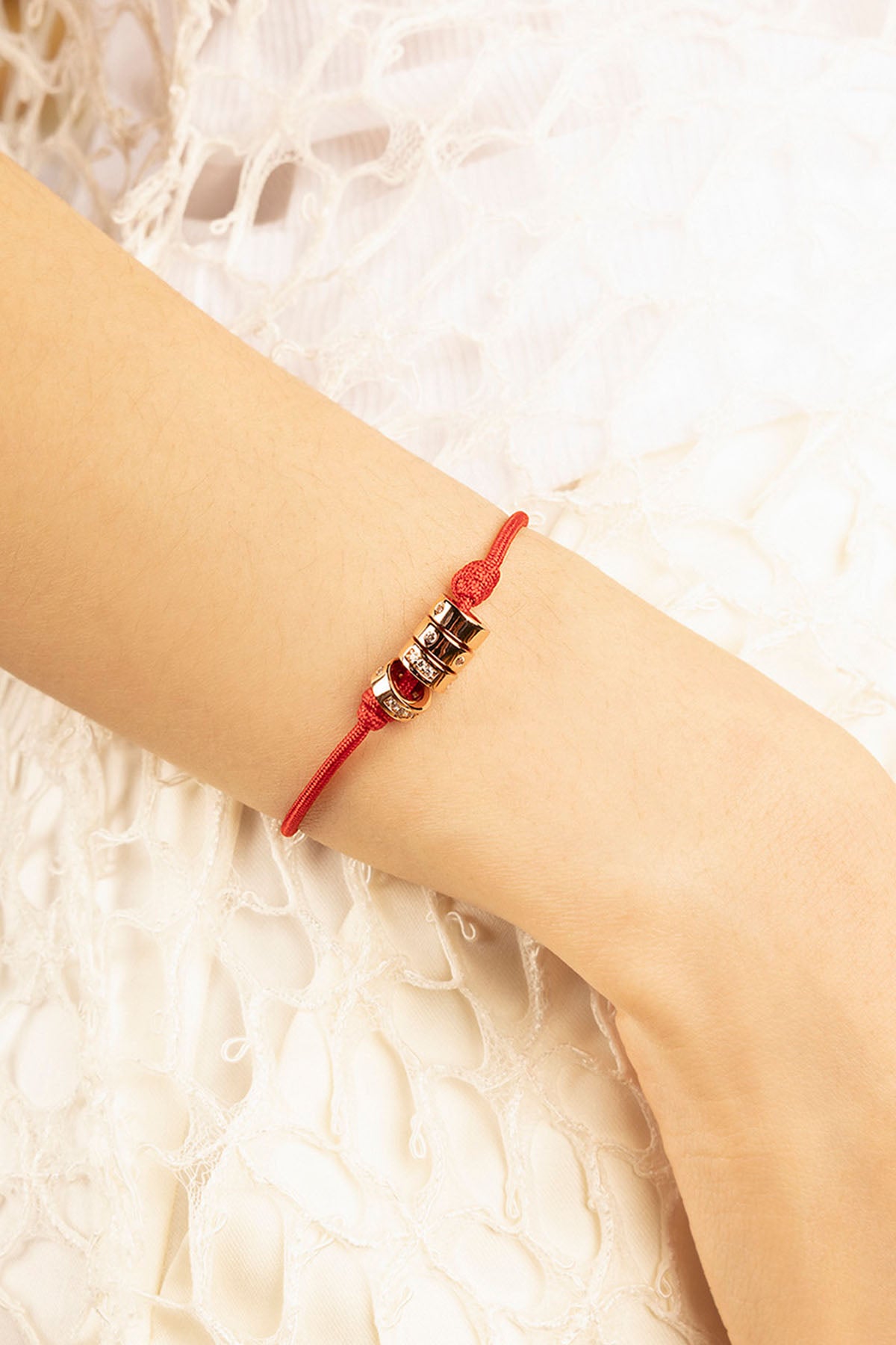 Red bracelet on a wrist with a soft white background