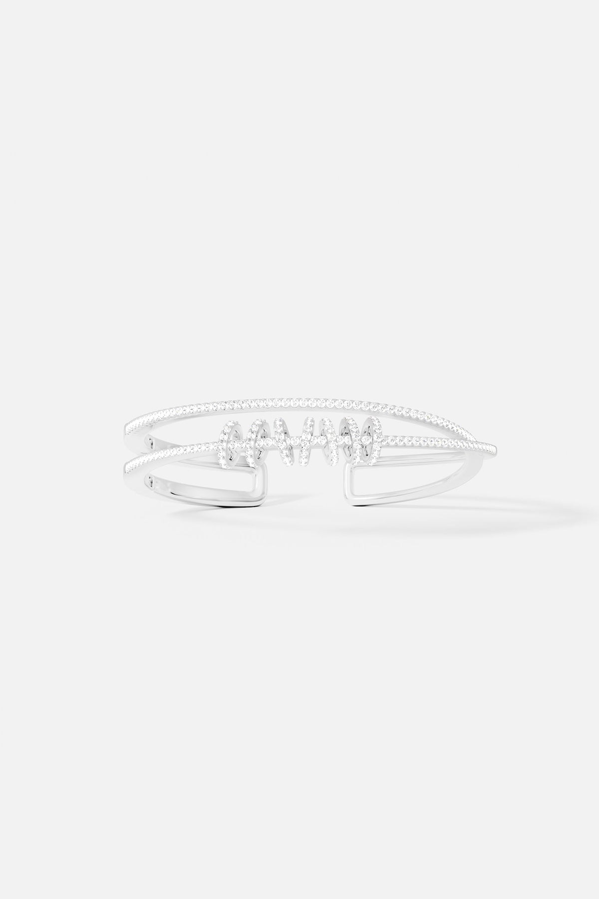 Bracelets APM Monaco. Silver-tone-tone double-open cuff with sliding rings and a row of pavé clear stones along the edge.