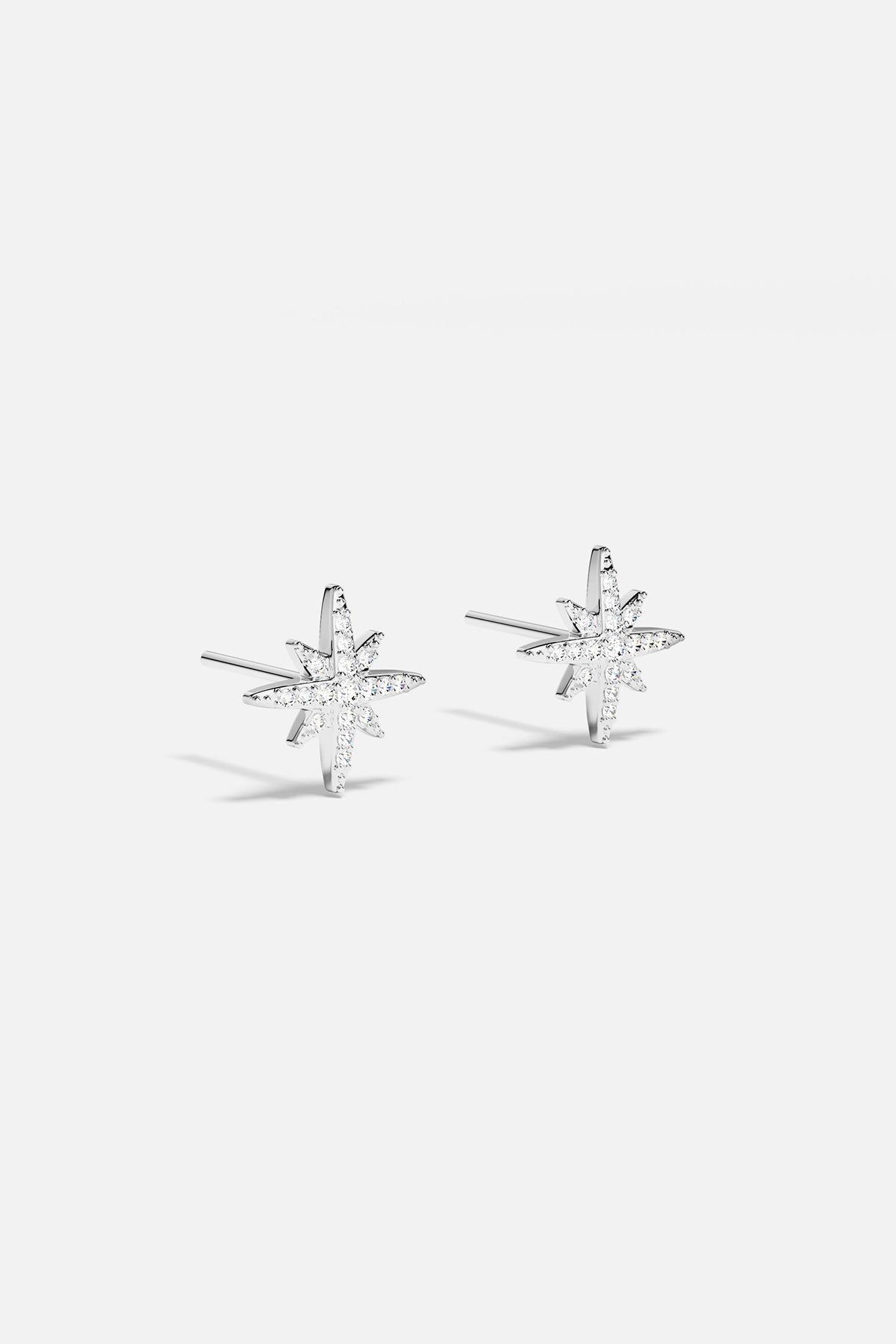 Earrings APM Monaco: Silver-tone starburst stud earrings with white stones.