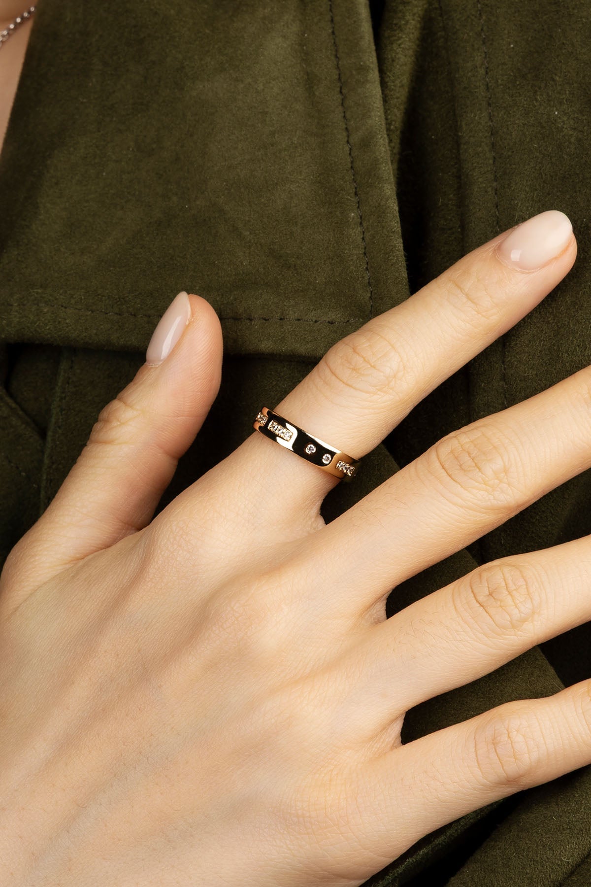 Hand wearing a ring on a green background
