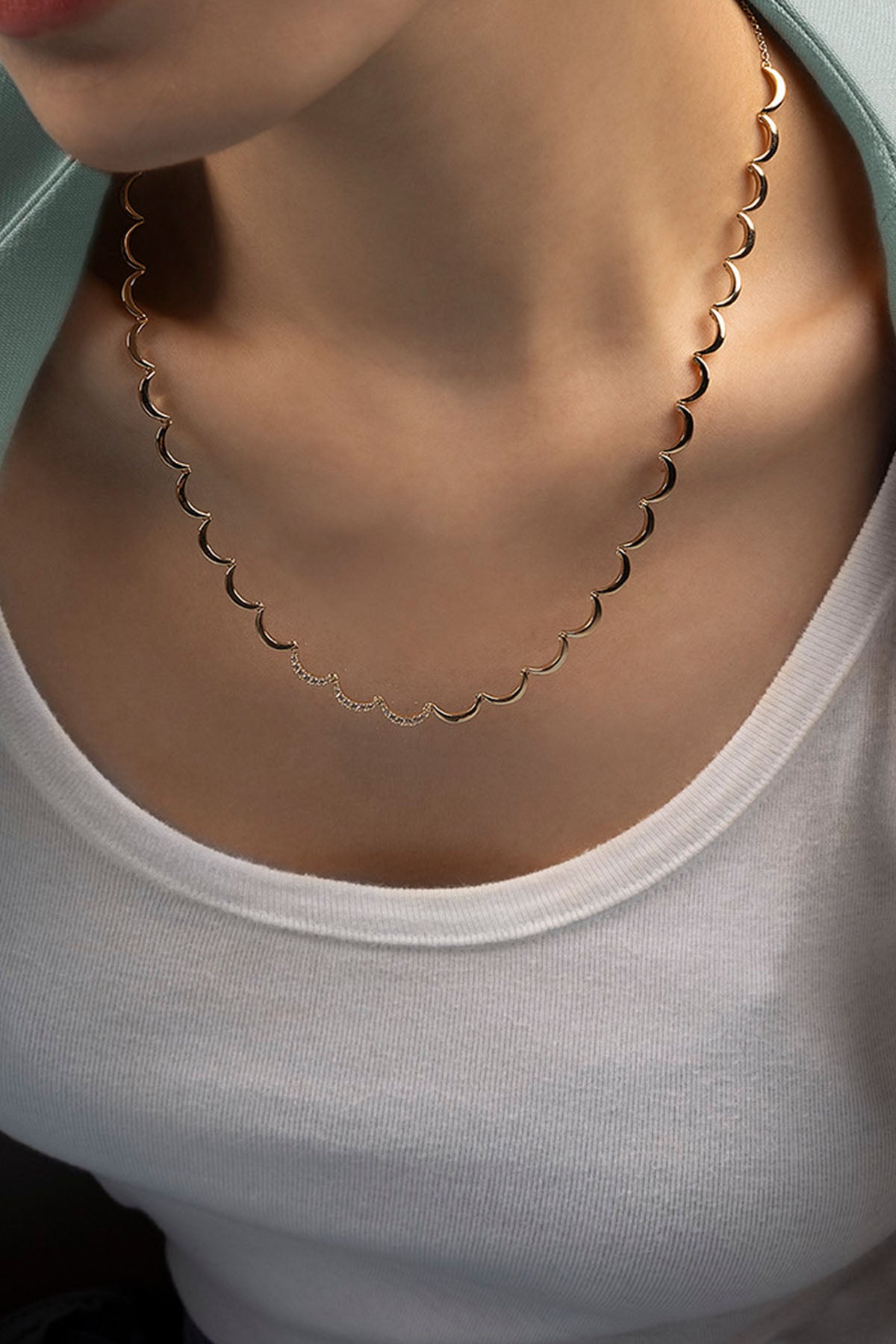Gold necklace worn by a person