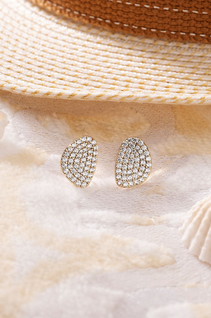 APM Monaco Pavé Galet Stud Earrings in Yellow Gold on soft blanket