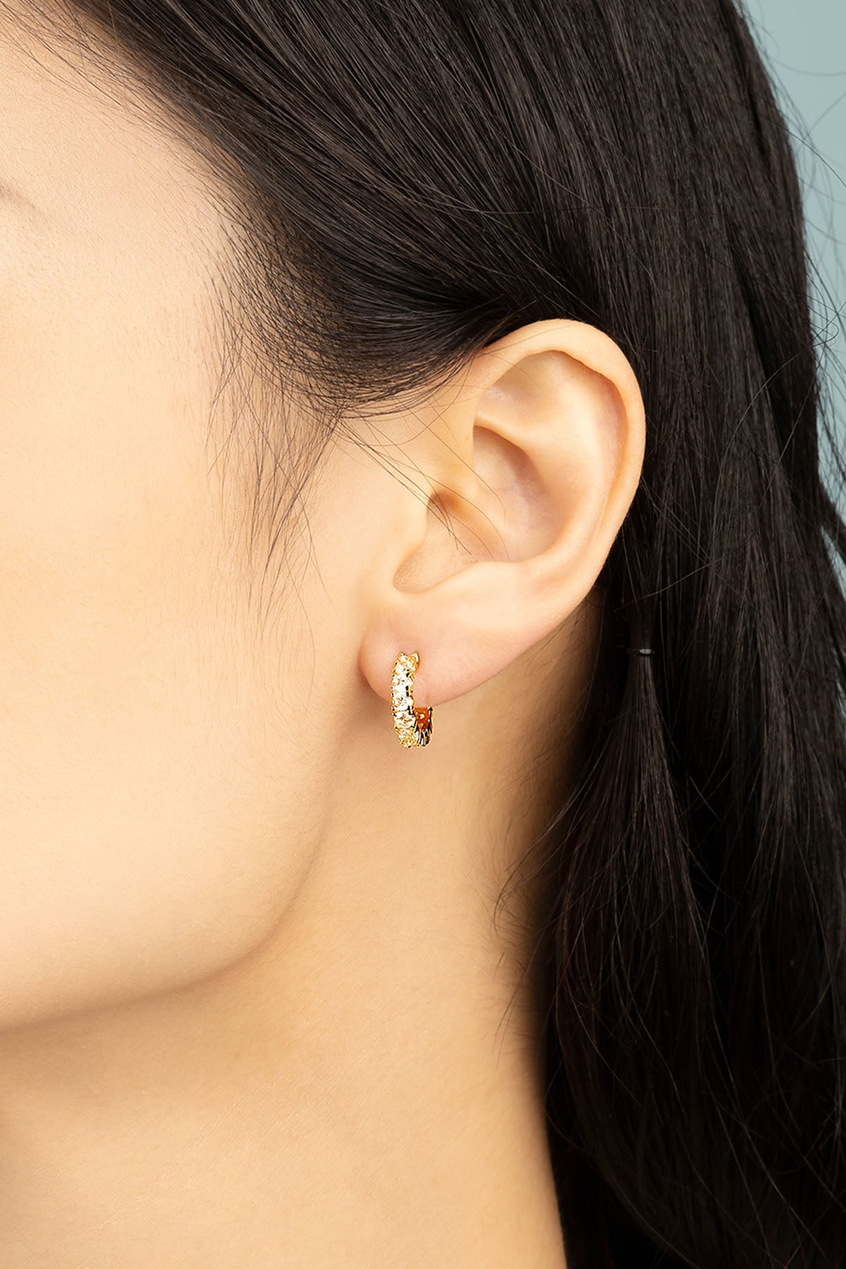 APM Monaco Pavé Huggie Earrings in Yellow gold worn on ear