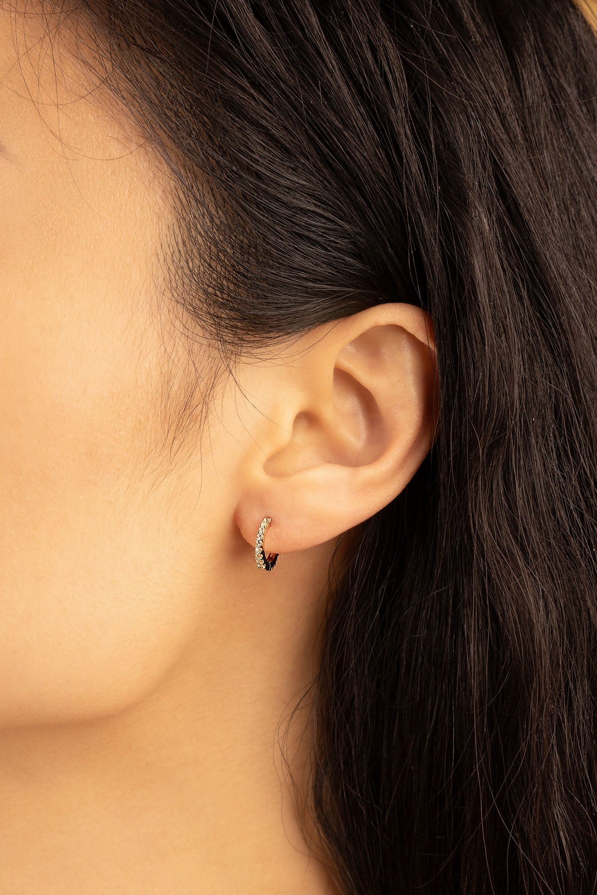 APM Monaco Pavé Gold Huggie Earrings in Gold worn on hand